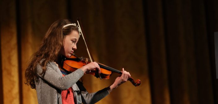 A student playing violin at the St. Peter's Community Arts Academy